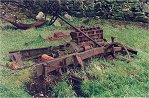 A rusty truck with a six cylinder engine in a field, in The Lake District by Thomas McNamara